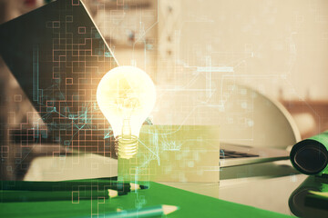 Poster - Computer on desktop in office with bulb icon hologram. Multi exposure. Concept of idea.