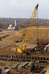 Wall Mural - The work of cranes and other equipment at the construction site of the bridge across the river