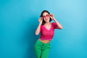 Sticker - Photo of gorgeous pretty girl with curly hairdo dressed pink top hands touch sunglass look empty space isolated on blue color background