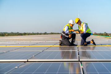 Wall Mural - professional man engineer using digital tablet maintaining solar cell panels together on building ro