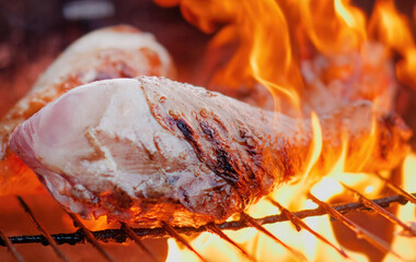 Wall Mural - Delicious marinated Turkey Drumsticks thighs on a wood grill in slow motion