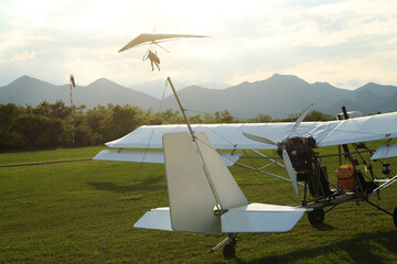 Wall Mural - Modern white airplane on green grass outdoors