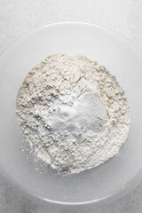 All purpose flour and baking powder in a bowl, baking flour in a large bowl