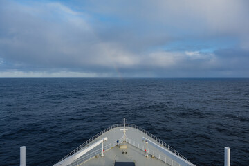 Rainbow at sea after storm during transatlantic passage on legendary ocean liner cruiseship cruise ship on Atlantic Ocean with cloud and seascape