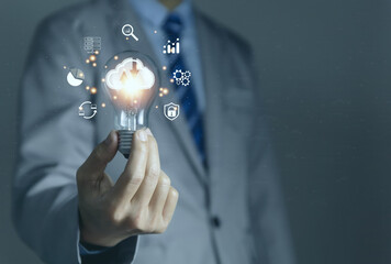 Businessman holding a light bulb showing a diagram of Cloud computing information technology icon.