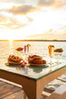 Thai cuisine set with a waterfront restaurant at sunset.