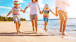 © candy1812 - Family with holding hands running along seacoast.