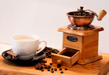 filiżanka kawy, ziarna kawy i stary młynek do kawy