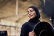 © Flamingo Images - Smiling muslim woman holding a weight in a gym