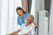 © SKW - Man being cared for by a private Asian nurse at home suffering from Alzheimer's disease to closely care for elderly patients with copy space on left