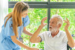 © SKW - Man being cared for by a private Asian nurse at home suffering from Alzheimer's disease to closely care for elderly patients with copy space on left