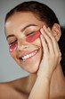 © K.A./peopleimages.com - Black woman, eyes patch and facial beauty wellness, cosmetics dermatology and closed eye or skincare treatment happiness. African model, smile and glowing skin or spa facial mask product in studio