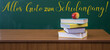 Alles Gute zum Schulanfang Hintergrund Karte, deutscher Text - Grüne Schultafel, Schulbücher und Apfel auf Lehrerpult in Klassenzimmer einer Schule