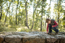 Boy Exploring On A Rock Wall