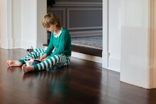 Boy In Elf Pajamas Playing With Robot Toy 2