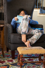 Girl Reading Book In Grand Wingback Chair Closer Up 2