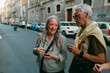 © Jimena Roquero/Stocksy - Senior tourist couple chatting in old Italian city street