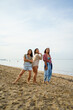 © Jovo Jovanovic/Stocksy - Female friends posing on sea shore at beach with sky in background