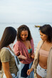 © Jovo Jovanovic/Stocksy - Woman showing seashell to friends at beach