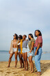 © Jovo Jovanovic/Stocksy - Happy female friends standing at beach with clear sky in background