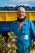 © Ezequiel Giménez/Stocksy - Smiling senior man standing near trailer with grapes