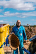© Ezequiel Giménez/Stocksy - Senior man with basket standing in farmyard in sunlight