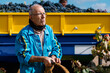 © Ezequiel Giménez/Stocksy - Serious senior man carrying basket near truck in farm