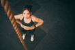 © K.A./peopleimages.com - Rope climbing, gym and fitness woman with focus for sports challenge, full body workout and healthy training. Female athlete, climb exercise and top view with power, strong mindset and motivation