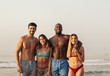 © Pedro Merino/Stocksy - Group of friends in swimwear on the beach