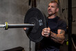 © Bisual Studio/Stocksy - Sportsman putting weight plate on barbell