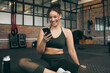 © K.A./peopleimages.com - Happy woman, fitness and phone at gym for a workout, training and body wellness with a mobile app. Sports female with smartphone for progress, performance and communication for a healthy lifestyle