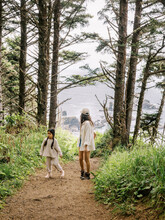 Mom And Daughter Hiking On Forest Coast Trail