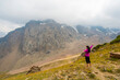 © Cavan Images - High angle view of happy woman with arms outstretched standing on mountain