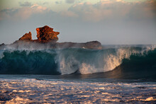 Large Wave Curls In Front Of A Rock.