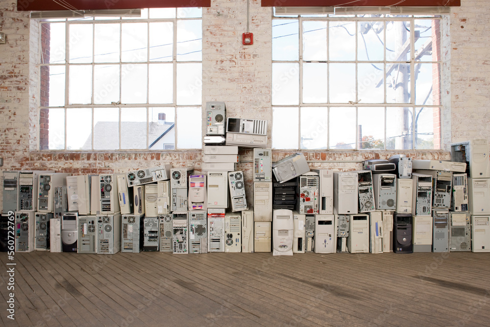 Stacks of old computer towers line the wall of an old warehouse ...