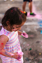 Happy Child Playing With Paints On Street