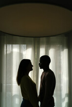 Anonymous Couple Against Window At Home