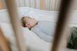 © Tanya Yatsenko/Stocksy - A baby sleeping in a cot