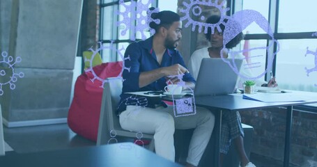 Canvas Print - Animation of pandemic icons over diverse business people using laptop