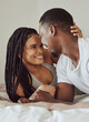 Black couple, love and home bedroom bonding while happy together on a bed in a house, apartment or hotel. Young man and woman intimate in a healthy marriage with commitment, happiness and care
