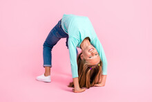 Full Body Portrait Of Cheerful Nice Schoolkid Upside Down Make Bridge Isolated On Pink Color Background