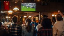 Group Of Friends Watching A Live Soccer Match On TV In A Sports Bar. Excited Fans Cheering And Shouting. Young People Celebrating When Team Scores A Goal And Wins The Football World Cup.