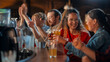 © Gorodenkoff - Group of Soccer Fans Sitting at a Bar Counter, Drinking, Watching a Live Football Match Broadcast on TV. People Cheering, Supporting Their Team. Crowd Goes Ecstatic When Team Scores a Decisive Goal.