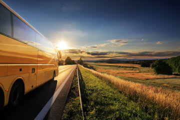 Wall Mural - Yellow bus on the road at sunset.