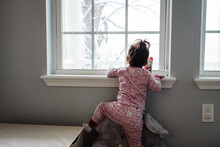 Little Girl Looking Out Window At Snow