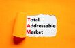 TAM total addressable market symbol. Concept words TAM total addressable market on white paper on a beautiful orange background. Business TAM total addressable market concept. Copy space.