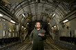 © Cavan Images - A U.S. Air Force loadmaster runs down her checklist in the cargo area during preflight.