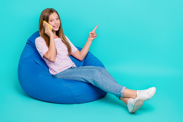 Canvas Print - Full length photo of charming pretty girl dressed pink t-shirt bean bag speaking gadget empty space isolated teal color background