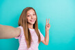 Portrait of lovely nice girl toothy smile make selfie demonstrate v-sign isolated on turquoise color background