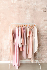 Wall Mural - Rack with stylish female clothes near pink wall